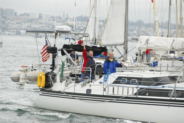 several people in blue jackets on a sailboat