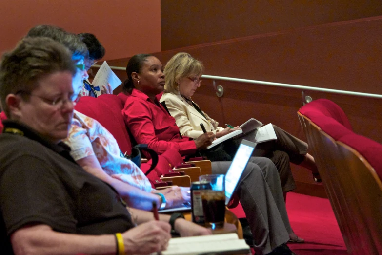 some women sitting in a room and reading books