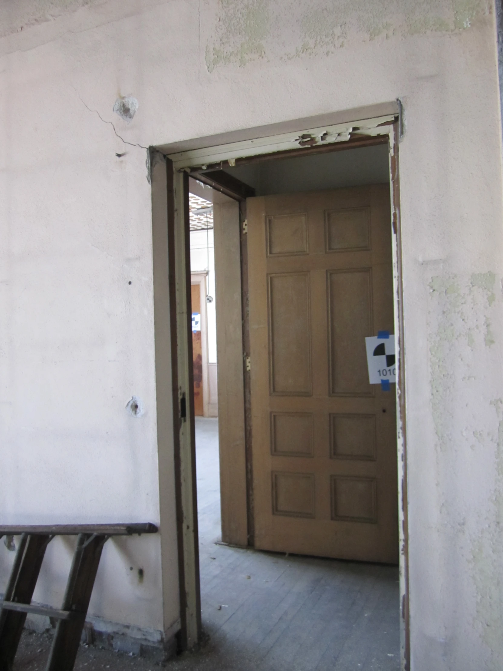 the entrance to an empty room with a door that is partially closed