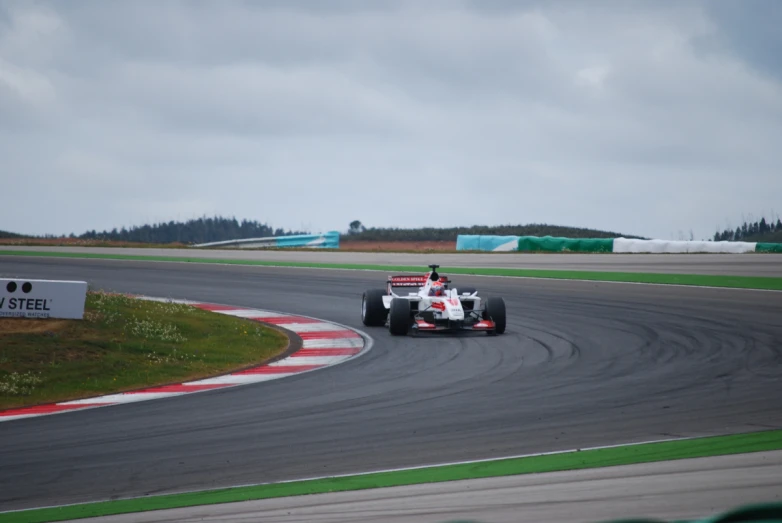 a driver is driving a red racing car on a track