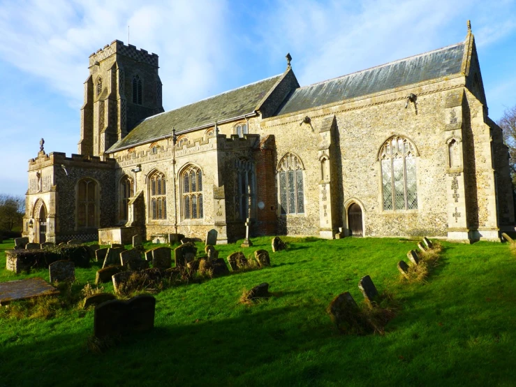 an old stone church on a green grassy hill