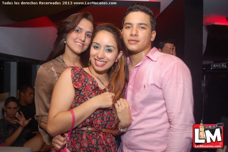 three people standing together in a room with one woman taking the camera