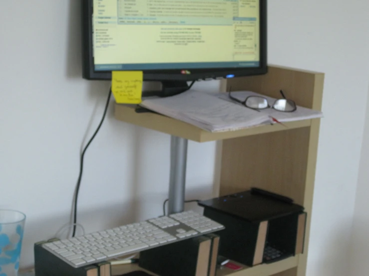 computer monitor on a stand with keyboard and mouse