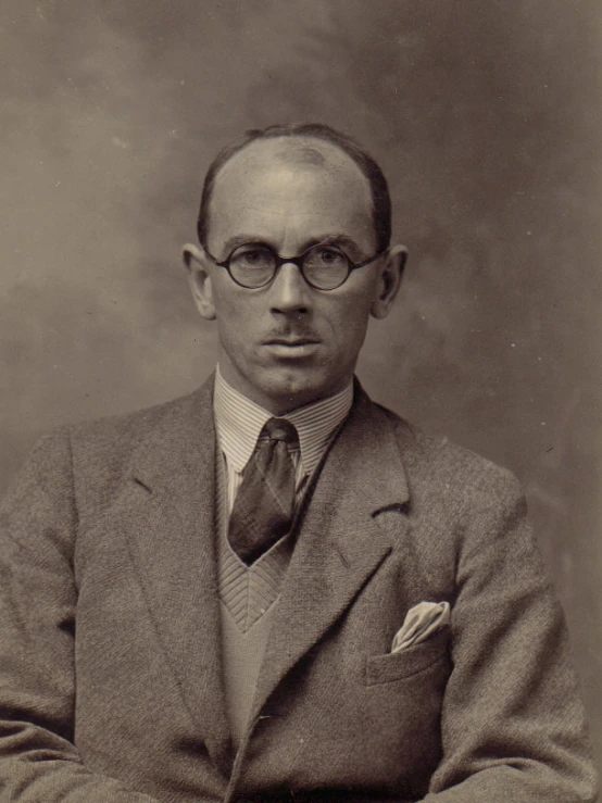 an older man in glasses and a suit and tie