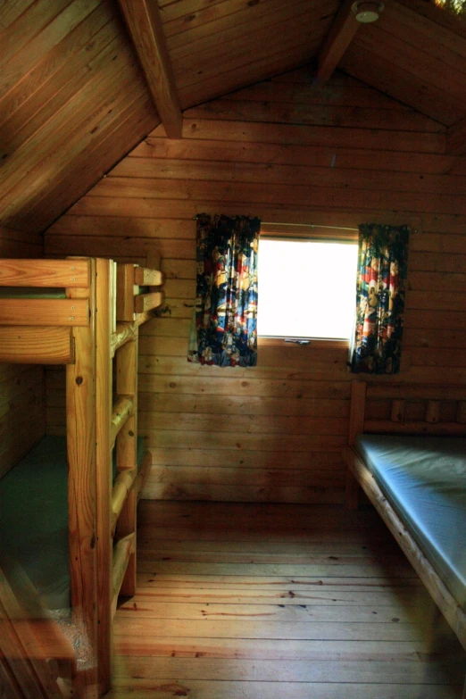 wooden bunk beds are placed in an attic dorm