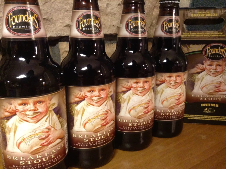 six bottles of brown ale on a table with other beer cans