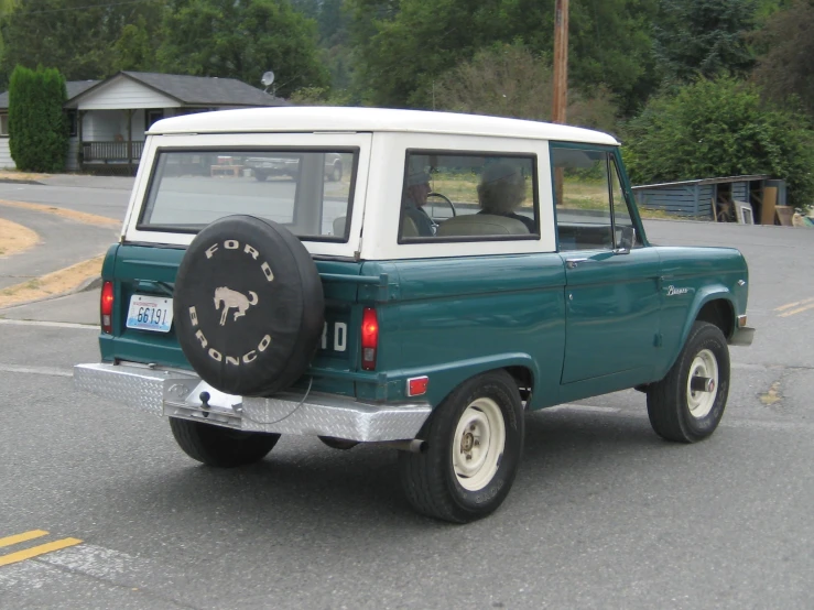 a green and white ford bronco pick up truck