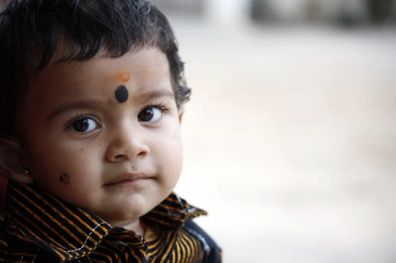 a child looking straight ahead with a black foreheadband