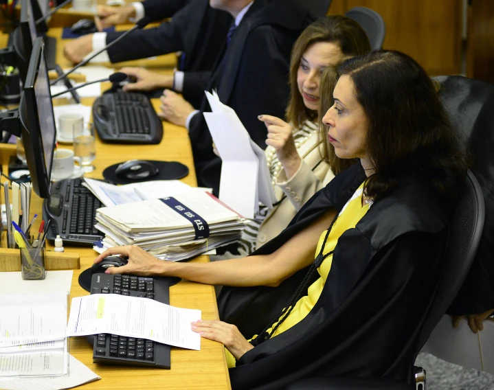 people sitting in front of a desk and one is on the phone