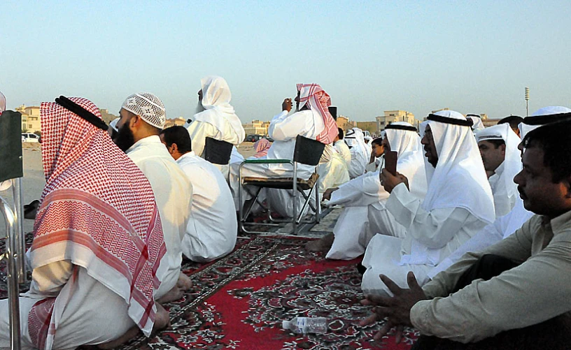 a group of people dressed in burqi outfits sitting on rug