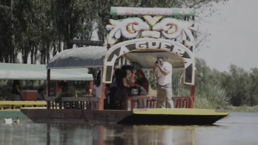 a man standing at the front end of a boat on a river