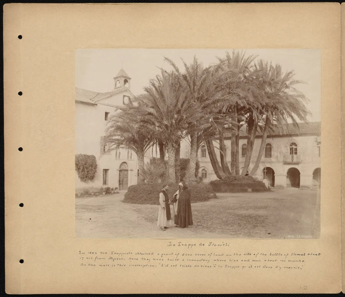 two people are standing outside in front of an old mansion