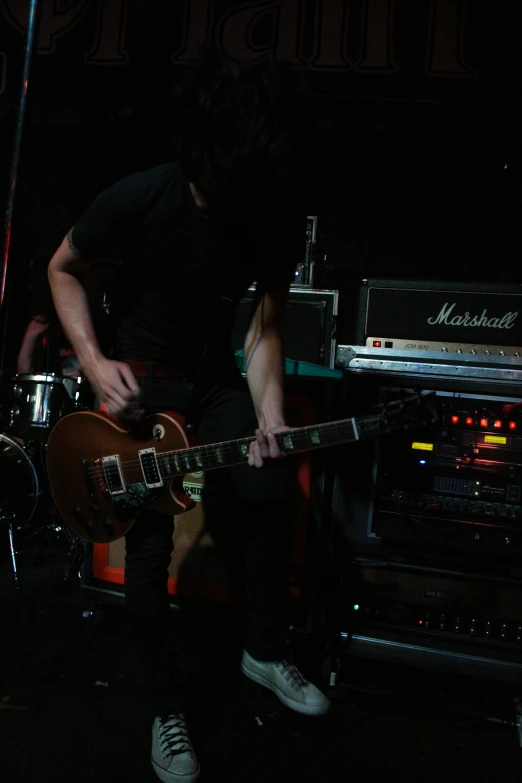 a man is playing a guitar on stage