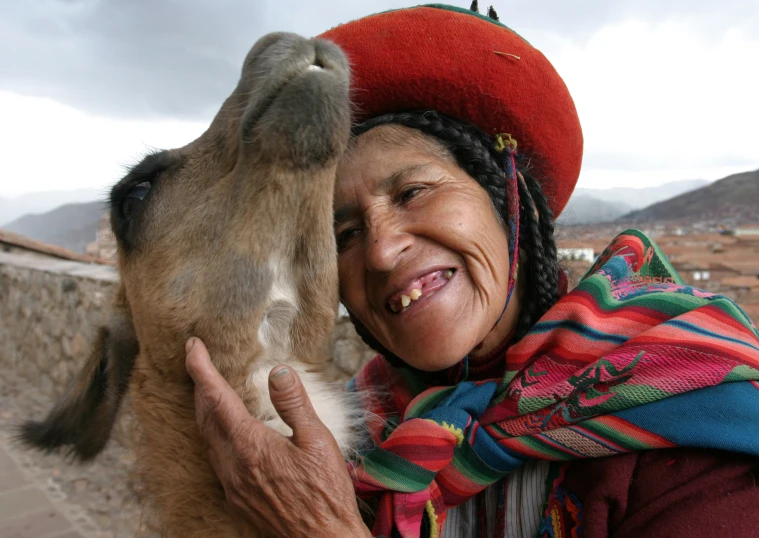 a woman holds up an animal with its mouth wide open