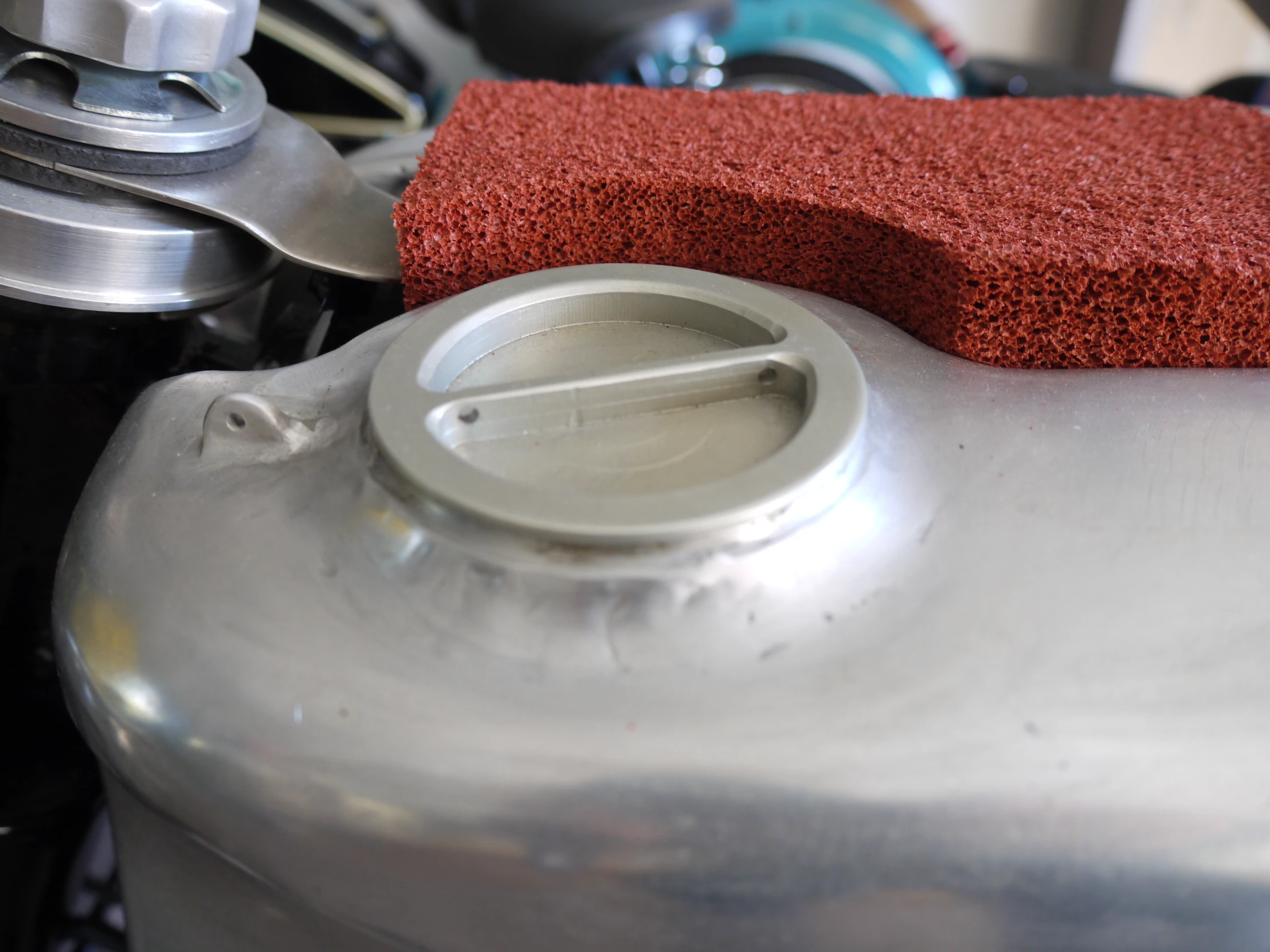 a soap scrubber sitting on top of a silver pot