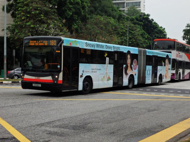 a bus going down the road with advertits on the side