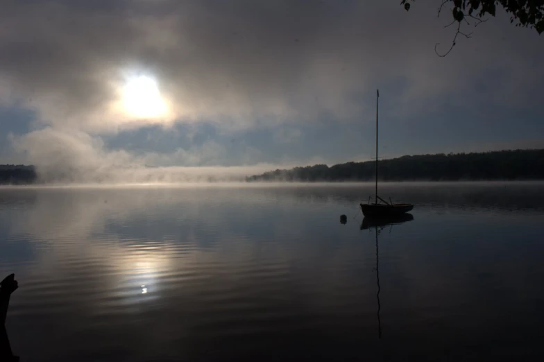 the fog on a lake near a boat in the distance