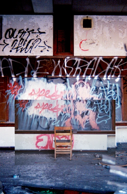 a chair sitting in front of graffiti covered walls