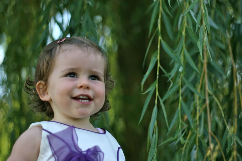 a little girl in purple and white smiling