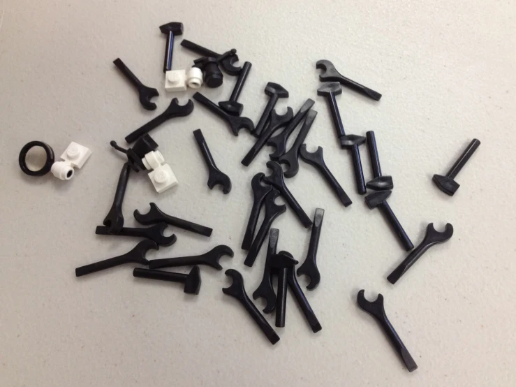 an assortment of black and white screws are on the floor