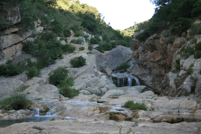 waterfall flowing down stream between rocks and vegetation