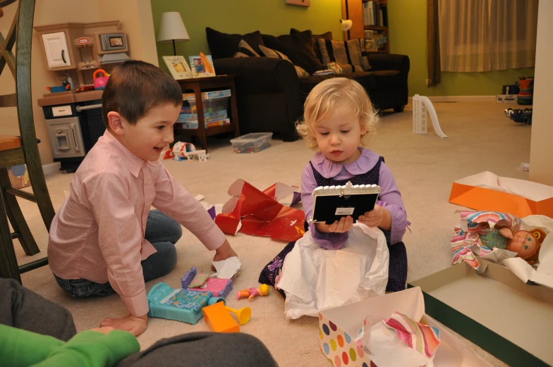 two small children play with toys on the floor