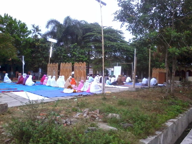 many people sitting on their beds in the park