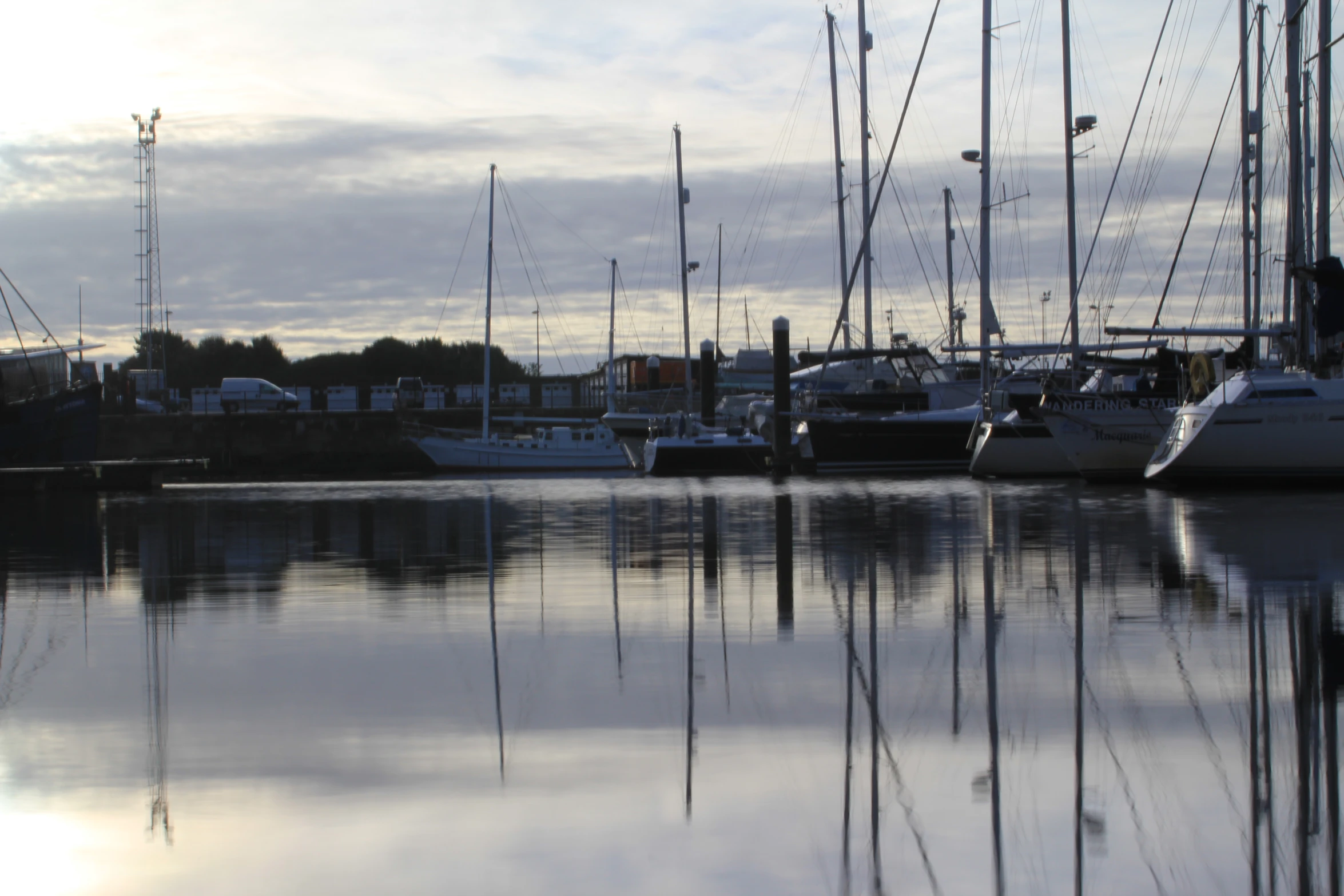 multiple boats in a large body of water near buildings