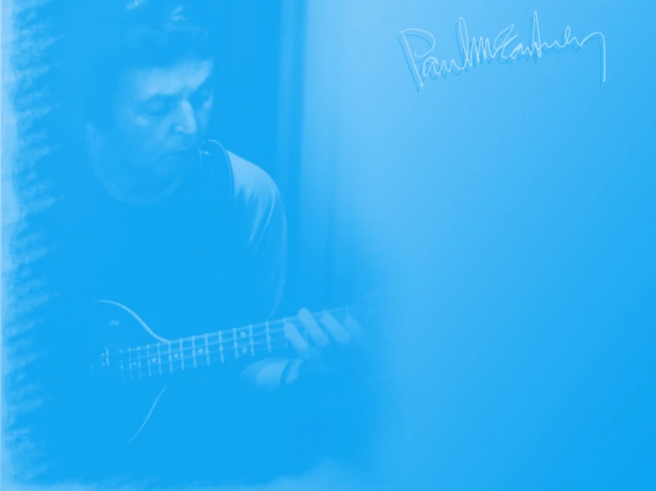 a man is playing a guitar in a blue room