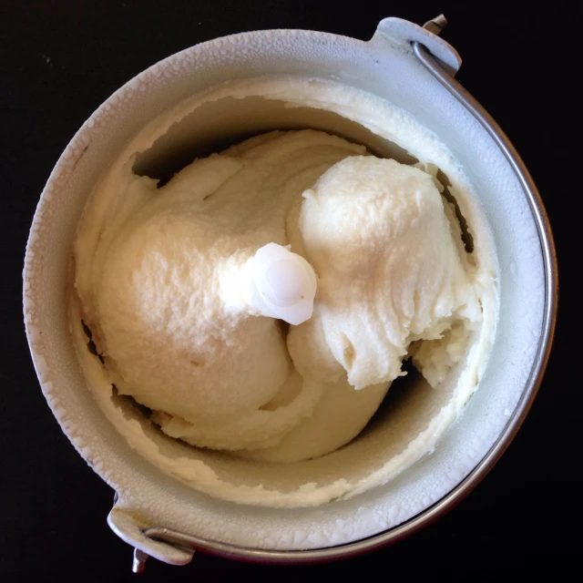the ice cream is in a bowl with two white spoons