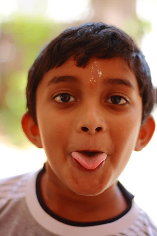 a  making a goofy face as he shows his tongue out