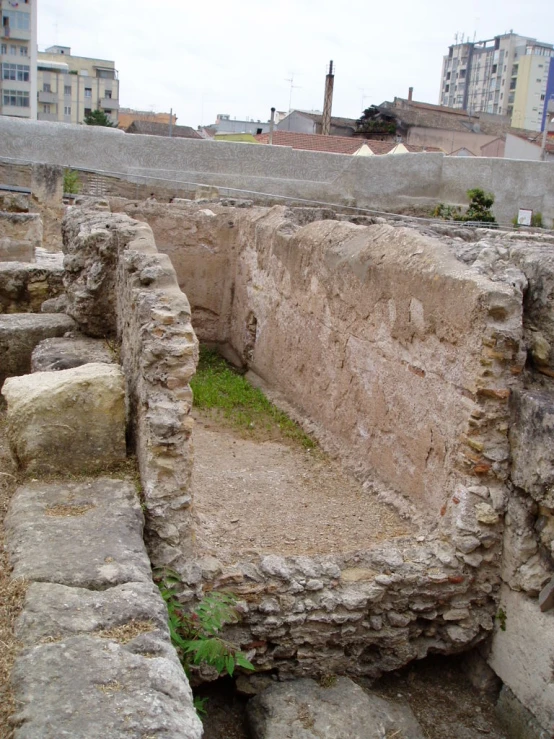 a stone structure with grass in the center