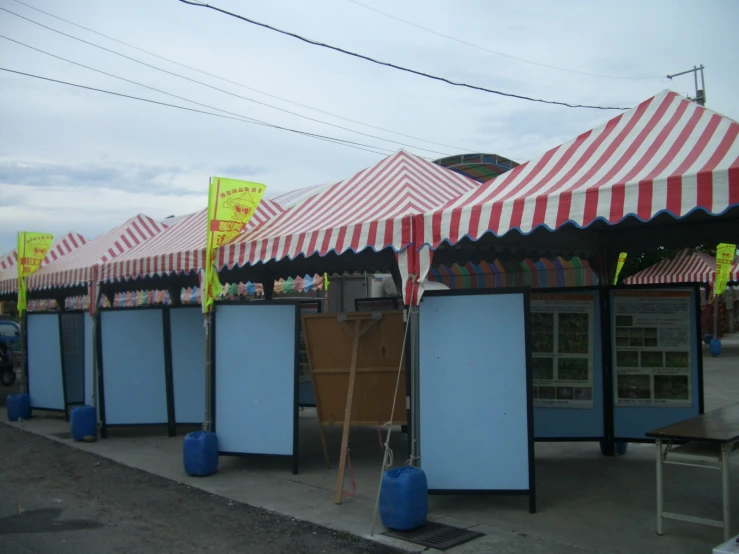 some tents lined up with wooden signs on them