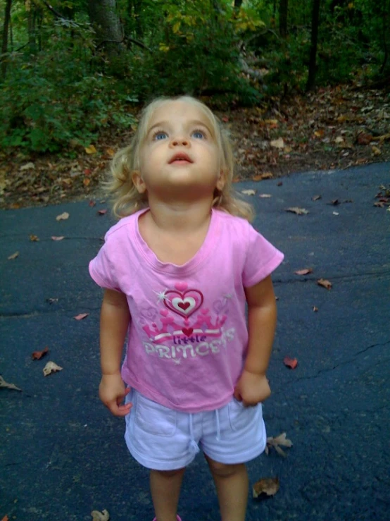 an adorable little girl looking up with her mouth open