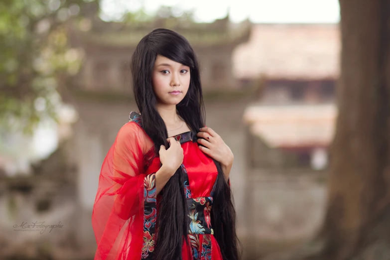 a beautiful asian woman in a long red dress