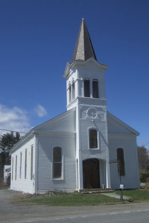 a white church sitting on a quiet street