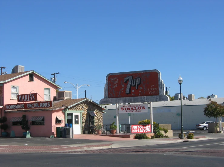 a pink restaurant with a big red sign above it