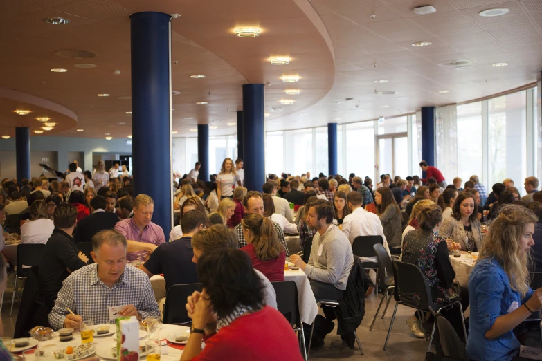 a large room full of people sitting at tables