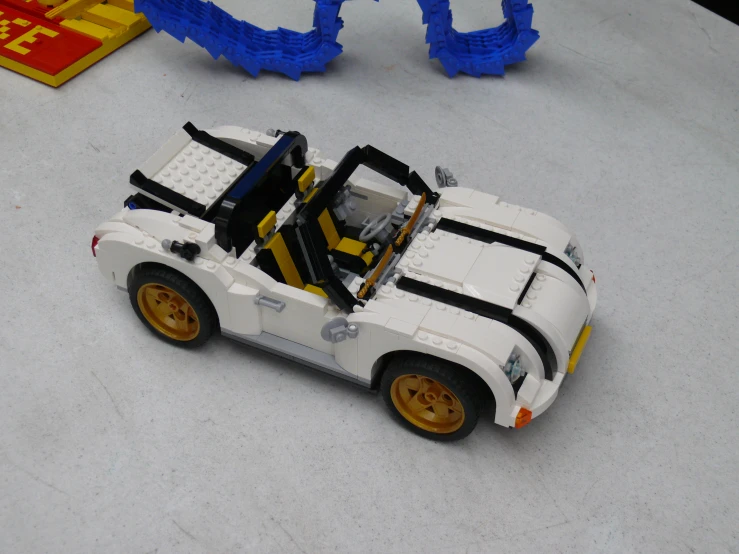 a car is sitting on the table and some legos are behind it