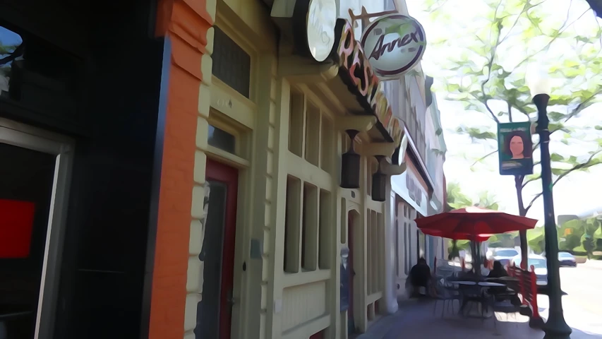 a side view of the outside of a restaurant with several tables and chairs