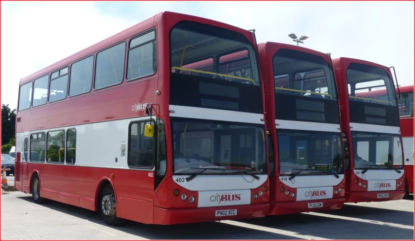 two red and white double decker buses on the street