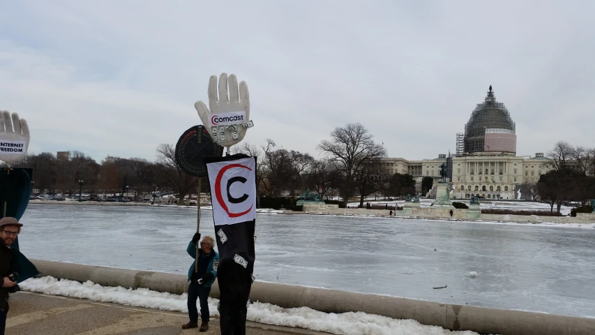 people holding up signs with a capitol building in the background