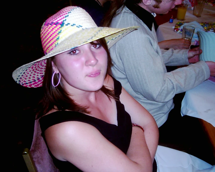 a woman in a pink hat sitting at a table