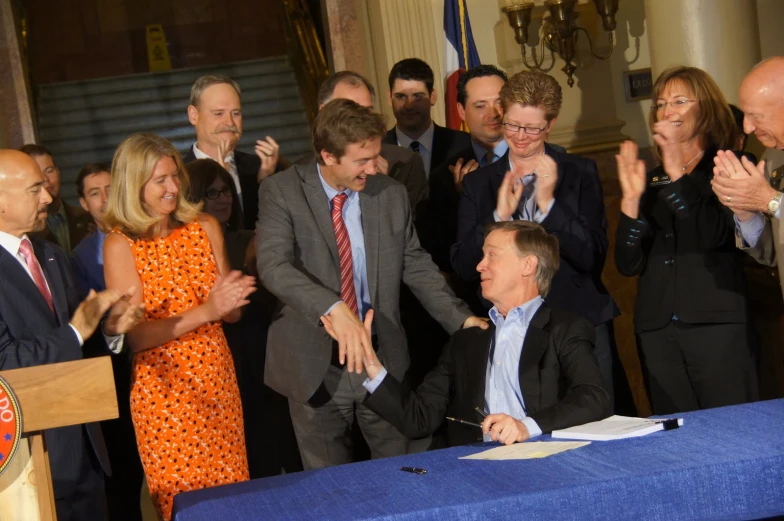 a group of people standing around a blue table