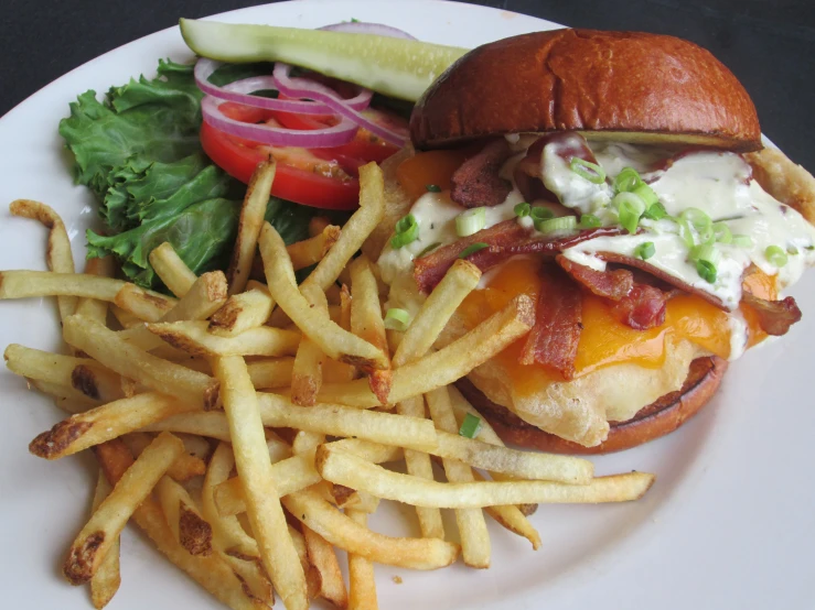 the burger has been served with potato wedges and tomatoes