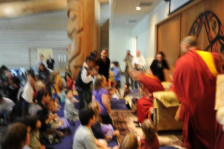 people sitting on the floor watching a monk give instructions