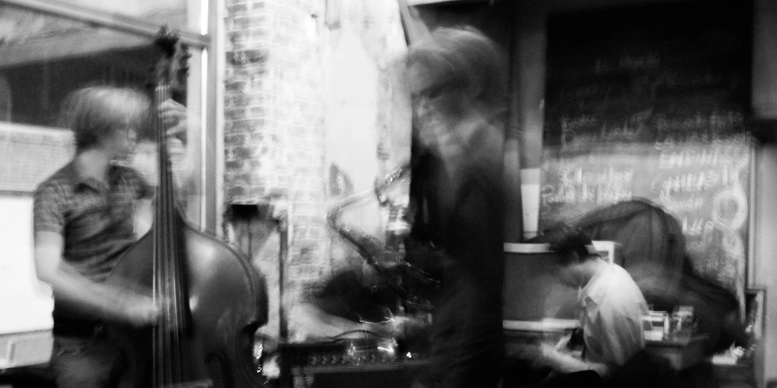 a blurry image of the back side of two men with guitars