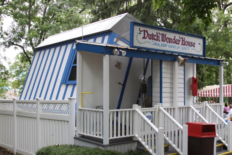 an old white wooden house with blue and white stripes