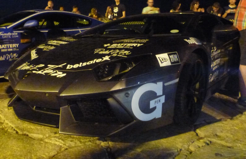 a man standing next to his race car