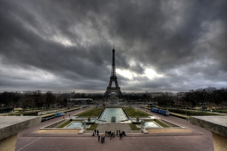 a group of people standing around in front of the eiffel tower